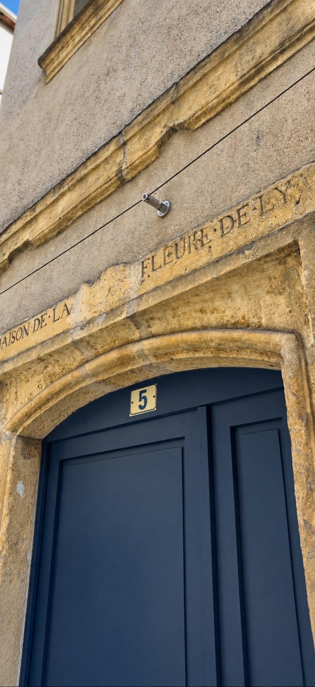 Porte bleue numéro 5 sous un linteau gravé Maison de la Fleur de Ly